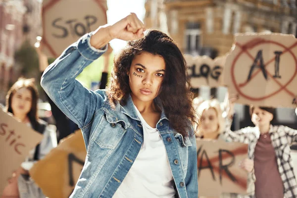 The power of a woman Young and strong woman is protesting for women empowerment with group of female activists while marching on the road.