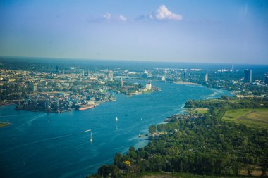 Güzel bir aero manzara Riga ve alan bir küçük uçak pencereden dışarı bakıyor. Riga, Letonya, Avrupa'da yaz. Güneşli, puslu bir gün otantik uçan deneyimi. Aero manzara