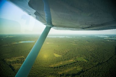 Güzel bir aero manzara kanatları altına küçük uçak pencereden dışarı bakıyor. Riga, Letonya, Avrupa'da yaz. Güneşli, puslu bir gün otantik uçan deneyimi. Havadan manzara.