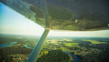 Güzel bir aero manzara kanatları altına küçük uçak pencereden dışarı bakıyor. Riga, Letonya, Avrupa'da yaz. Güneşli, puslu bir gün otantik uçan deneyimi. Havadan manzara.