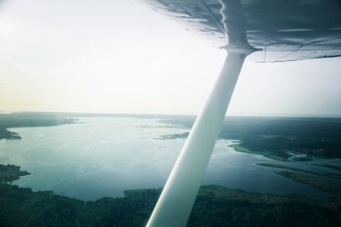 Güzel bir aero manzara kanatları altına küçük uçak pencereden dışarı bakıyor. Riga, Letonya, Avrupa'da yaz. Güneşli, puslu bir gün otantik uçan deneyimi. Havadan manzara.