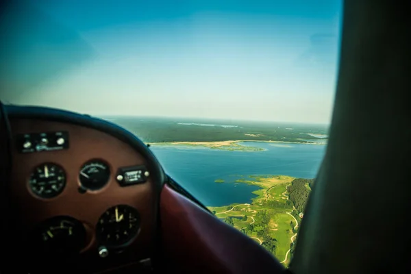 A beautiful aero landscape of a Baltic sea looking out of a small plane cockpit. Riga, Latvia, Europe in summer. Authentic flying experience in a sunny, hazy day. Flying small plane.