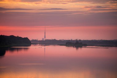 Parlak, renkli akşam peyzaj pembe ve mor ton Daugava Nehri üzerinde. Letonya, Kuzey Avrupa dramatik günbatımı manzara.