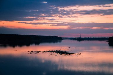 Parlak, renkli akşam peyzaj pembe ve mor ton Daugava Nehri üzerinde. Letonya, Kuzey Avrupa dramatik günbatımı manzara.