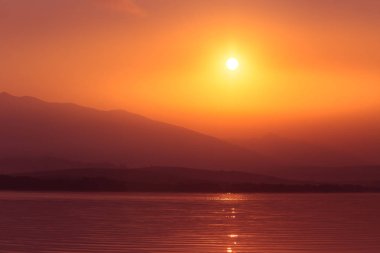 Güzel gün doğumu dağlar mesafe ile göl üzerinde. Sabah manzarada sıcak tonları. Tatra Dağları Slovakya, Europe.