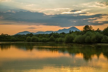 Göl, dağ ve orman ile bir güzel, renkli günbatımı manzara. Yaz aylarında dağ Gölü üzerinde doğal akşam sahne. Tatra Dağları Slovakya, Europe.