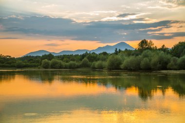 Göl, dağ ve orman ile bir güzel, renkli günbatımı manzara. Yaz aylarında dağ Gölü üzerinde doğal akşam sahne. Tatra Dağları Slovakya, Europe.