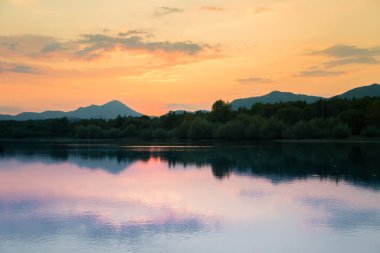 Göl, dağ ve orman ile bir güzel, renkli günbatımı manzara. Yaz aylarında dağ Gölü üzerinde doğal akşam sahne. Tatra Dağları Slovakya, Europe.