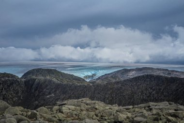Bir dağ manzarası ile uzaktan Folgefonna Buzulu. Buzdan uzak manzaralar. Norveç milli parkta sonbaharda.
