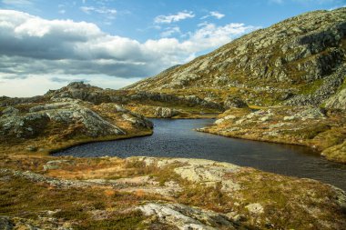 Güzel bir sonbahar dağ manzarası ile küçük bir göl. Doğal manzara Norveç dağlarında. Küçük su birikintisi dağlarda.