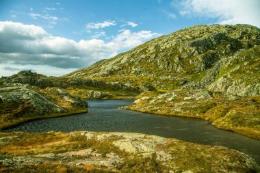 Güzel bir sonbahar dağ manzarası ile küçük bir göl. Doğal manzara Norveç dağlarında. Küçük su birikintisi dağlarda.