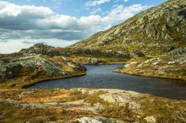 Güzel bir sonbahar dağ manzarası ile küçük bir göl. Doğal manzara Norveç dağlarında. Küçük su birikintisi dağlarda.