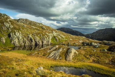 Güzel bir sonbahar dağ manzarası ile küçük bir göl. Doğal manzara Norveç dağlarında. Küçük su birikintisi dağlarda.