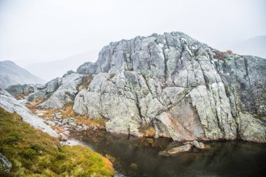Güzel bir sonbahar dağ manzarası ile küçük bir göl. Doğal manzara Norveç dağlarında. Küçük su birikintisi dağlarda.