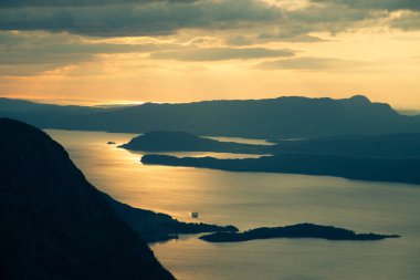 Norveç fiyortları üzerinde muhteşem bir günbatımı manzarası. Folgefonna Milli Parkı içinde güzel bir sonbahar manzara. Dramatik gökyüzü ve dağlar.