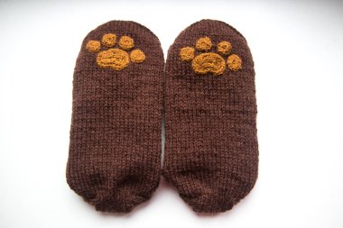 Güzel, sıcak el bir çift hayvan pençe desenli doğal bir iplik gelen yün çorap ördü. Beyaz arka plan.