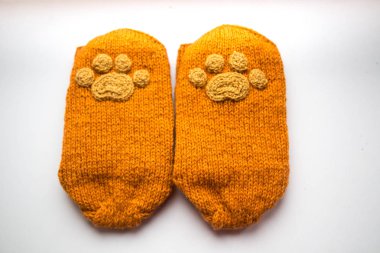 Güzel, sıcak el bir çift hayvan pençe desenli doğal bir iplik gelen yün çorap ördü. Beyaz arka plan.