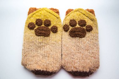 Güzel, sıcak el bir çift hayvan pençe desenli doğal bir iplik gelen yün çorap ördü. Beyaz arka plan.