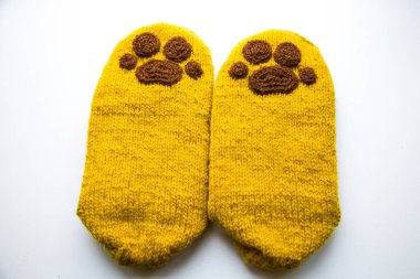 Güzel, sıcak el bir çift hayvan pençe desenli doğal bir iplik gelen yün çorap ördü. Beyaz arka plan.