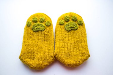 Güzel, sıcak el bir çift hayvan pençe desenli doğal bir iplik gelen yün çorap ördü. Beyaz arka plan.