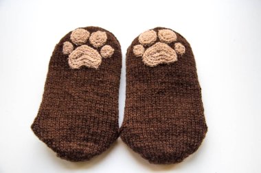 Güzel, sıcak el bir çift hayvan pençe desenli doğal bir iplik gelen yün çorap ördü. Beyaz arka plan.