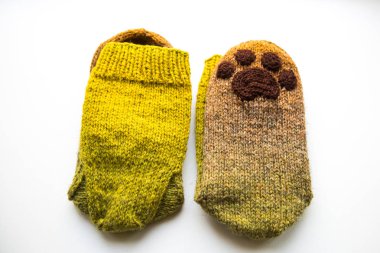 Güzel, sıcak el bir çift hayvan pençe desenli doğal bir iplik gelen yün çorap ördü. Beyaz arka plan.