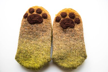 Güzel, sıcak el bir çift hayvan pençe desenli doğal bir iplik gelen yün çorap ördü. Beyaz arka plan.