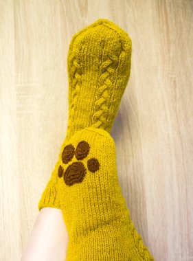 Sıcak el botu giyen bir kadın çorap. Doğal koyun yün iplik örme formu. Giyim Kış. Ahşap bir arka plan üzerinde.