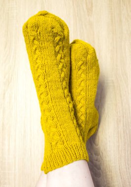 Sıcak el botu giyen bir kadın çorap. Doğal koyun yün iplik örme formu. Giyim Kış. Ahşap bir arka plan üzerinde.