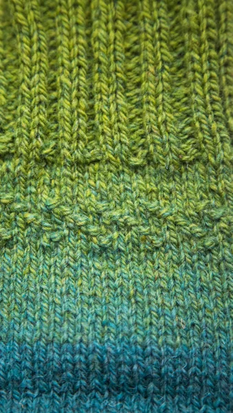 A beautiful closeup of a warm knitted pattern. Natural sheep wool yarn. Handcraft in bright colors.