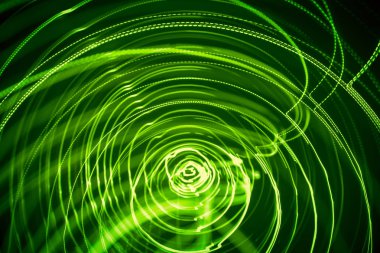 Yeşil renk bir güzel, parlak ışık girdap. Siyah bir zemin üzerine fütüristik ışık boyama. Yuvarlak açık daireler