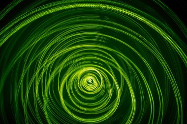 Yeşil renk bir güzel, parlak ışık girdap. Siyah bir zemin üzerine fütüristik ışık boyama. Yuvarlak açık daireler