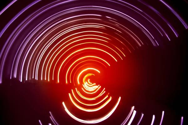 A beautiful, bright light swirl of colors. Futuristic light painting on a black background. Round light circles