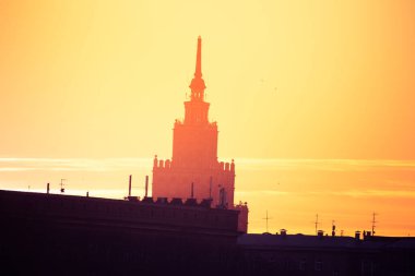 Güzel bir siluet gündoğumu sırasında şehirde bir kulenin. Riga, Letonya sabah sahne. Şehirde yüksek bina. Renkli cityscape.