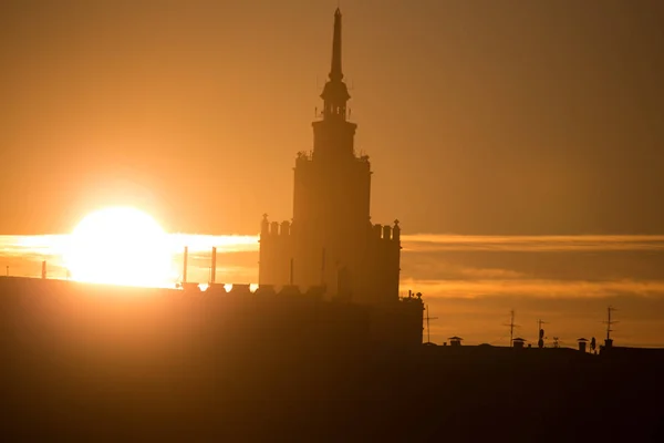 A beautiful silhouette of a tower in city during the sunrise. Morning scenery of Riga, Latvia. Tall building in city. Colorful cityscape.