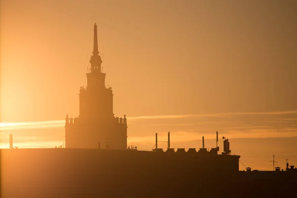 A beautiful silhouette of a tower in city during the sunrise. Morning scenery of Riga, Latvia. Tall building in city. Colorful cityscape.
