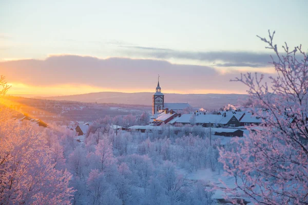 Küçük Norveç kasabası Roros'ta güzel gün batımı. Akşam güneşinde kilise. İskandinav kış manzarası.