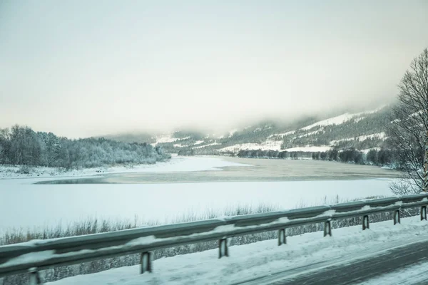 A beatiful winter scenery with a road. Woods in Norway. Scandinavian landscape with snow.