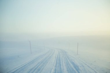 Kışın Norveç tepelerinde güzel, sisli bir sabah. Beyaz, puslu manzara. Küçük Norveç kasabası Roros yakınlarında.
