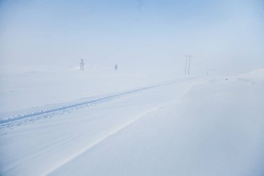 Kışın Norveç tepelerinde güzel, sisli bir sabah. Beyaz, puslu manzara. Küçük Norveç kasabası Roros yakınlarında.