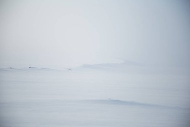 Kışın Norveç tepelerinde güzel, sisli bir sabah. Beyaz, puslu manzara. Küçük Norveç kasabası Roros yakınlarında.