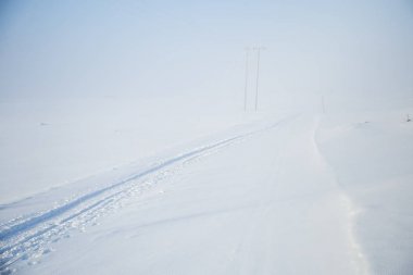 Kışın Norveç tepelerinde güzel, sisli bir sabah. Beyaz, puslu manzara. Küçük Norveç kasabası Roros yakınlarında.