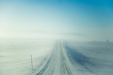 Kışın Norveç tepelerinde güzel, sisli bir sabah. Beyaz, puslu manzara. Küçük Norveç kasabası Roros yakınlarında.