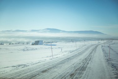 Kışın Norveç tepelerinde güzel, sisli bir sabah. Beyaz, puslu manzara. Küçük Norveç kasabası Roros yakınlarında.