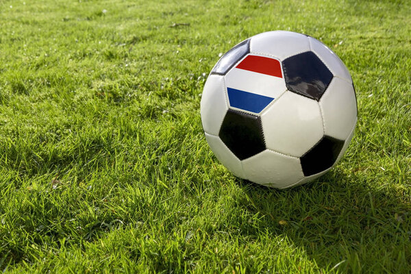 Football on a grass pitch with Netherlands Flag