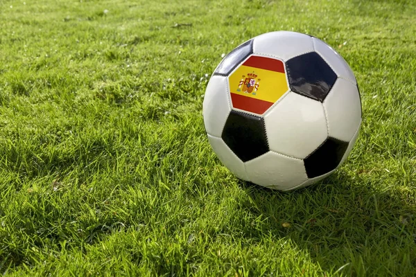 在草地上的足球与西班牙国旗 — 图库照片