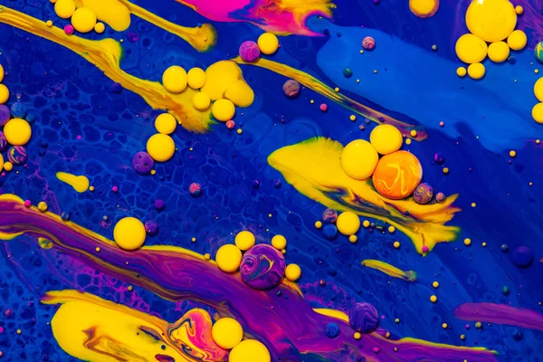 Acrylic paint balls abstract texture. Purple, blue and yellow liquids mix. Creative multicolor background. Bright colors fluid, flowing wallpaper design. Mixed pigments blue backdrop. — Stock Photo, Image