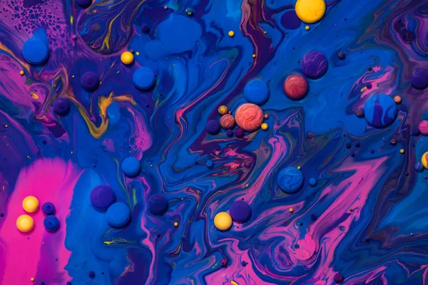 Vernice acrilica palle texture astratta. Liquidi rosa, blu e gialli si mescolano. Sfondo multicolore creativo. Colori vivaci fluido, fluido disegno carta da parati. Pigmenti misti sfondo blu . — Foto Stock