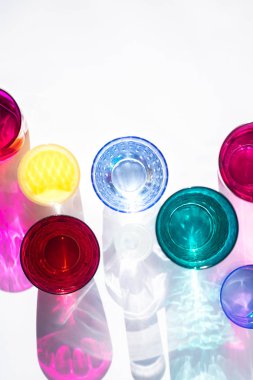 Cam kadehler bir güneş masa üzerinde harika renkli gölgeler oluşturun. Güneş ışığının gölgesi pembe ve sarı, zümrüt renklerin cam yansıtır. Üstte görüntü.