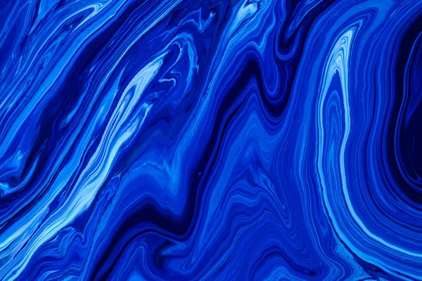 Fluid art texture. Backdrop with abstract swirling paint effect. Liquid acrylic artwork with flows and splashes. Classic blue color of the year 2020. Blue, white and indigo overflowing colors.